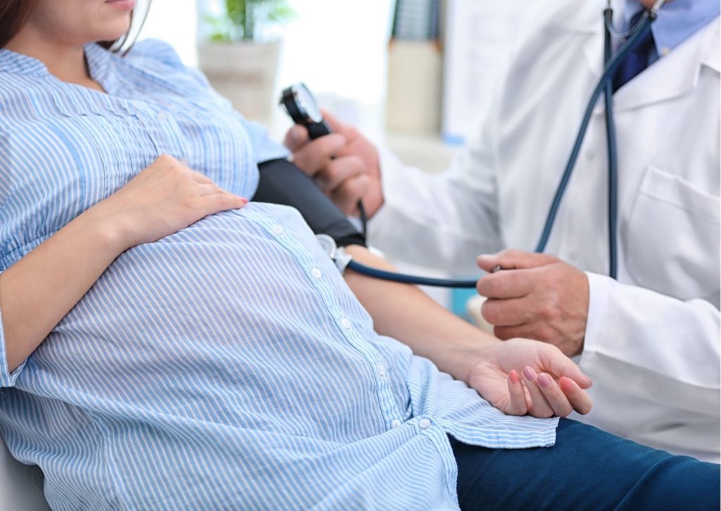 gestante sendo avaliada por médico no pré-natal