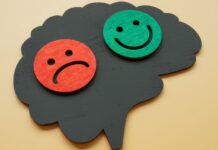 Com tantos tratamentos novos, por que o lítio ainda é referência no transtorno bipolar? cérebro com rosto feliz e rosto triste, representando o transtorno bipolar
