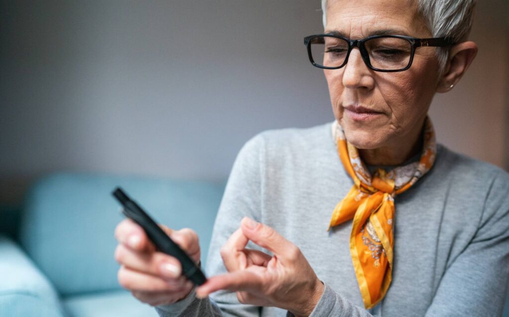 mulher avaliando glicemia capilar para o tratamento da diabetes tipo 2