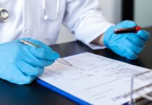 Homocisteína alta: quando investigar e o que o exame realmente indica médico analisando exame de homocisteína em amostra de sangue no laboratório