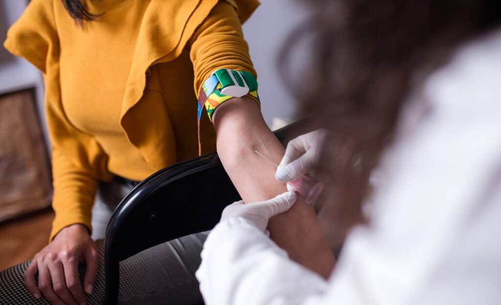 mulher realizando coleta de sangue para exame de CA 15-3 no câncer de mama