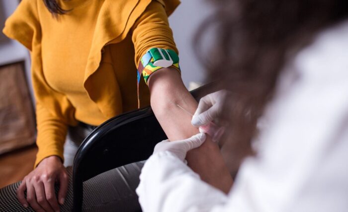 paciente realizando coleta de sangue para exame de PTH