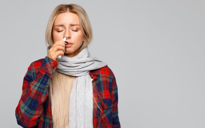 mulher com sintomas de rinite alérgica, utilizando spray intransal de avamys (fluticasona)