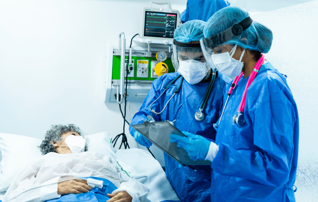 médicos avaliando prontuário de paciente grave em UTI, com possível bacteremia por Escherichia coli
