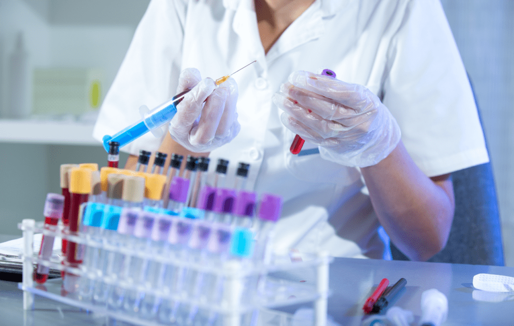 profissional de laboratório com seringa destampada, sofrendo um acidente com material biológico 