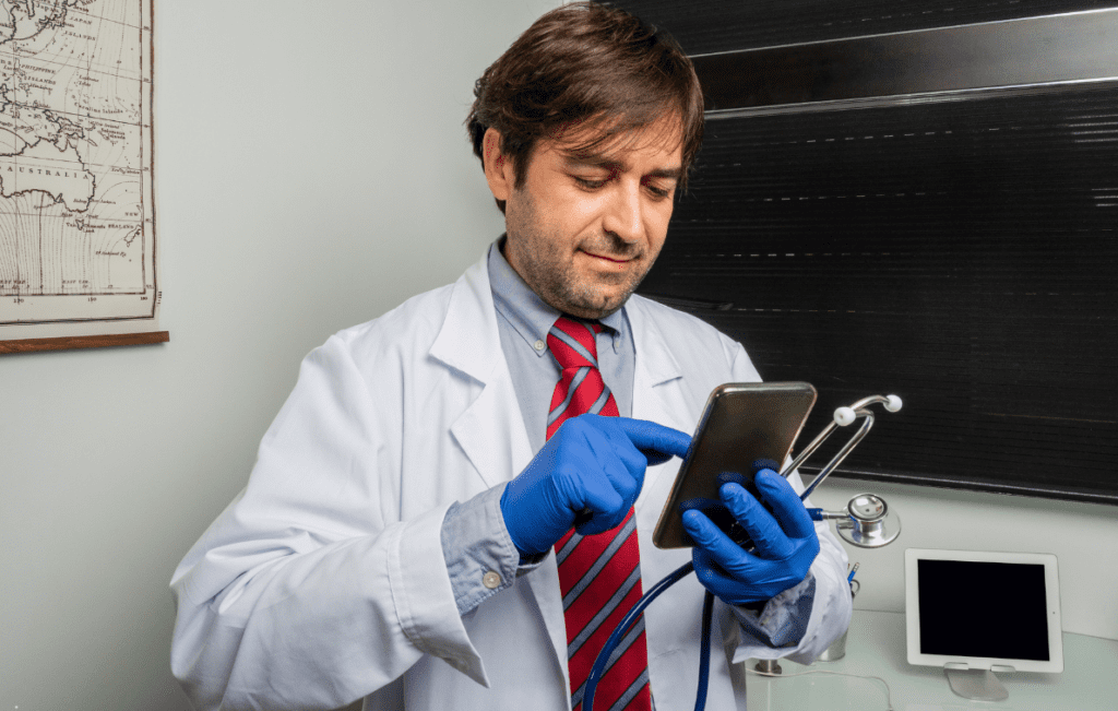 Médico consultando conteúdos clínicos sobre imunomoduladores e infecções recorrentes em aplicativo médico