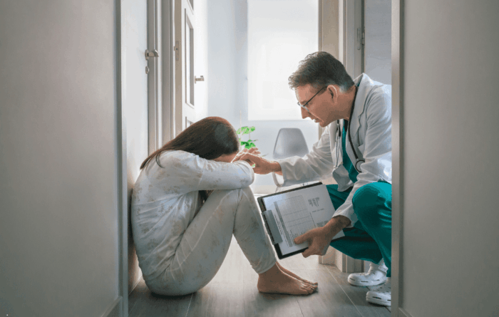 paciente encolhida chorando e sendo acolhida pelo médico, em monitorização quanto aos efeitos adversos do clonazepam