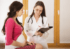Trombofilia na gestação: como prevenir TEV e quando usar enoxaparina Médica avaliando gestante com risco de trombofilia na gestação durante consulta pré-natal para prevenção de tromboembolismo venoso