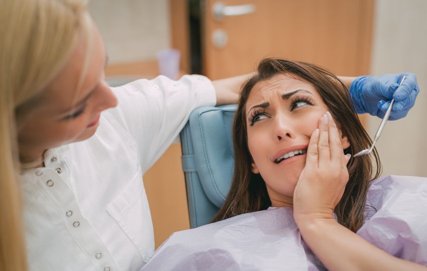 paciente com dor de dente no dentista, sendo orientada que Infecções odontogênicas podem causar angina de ludwig