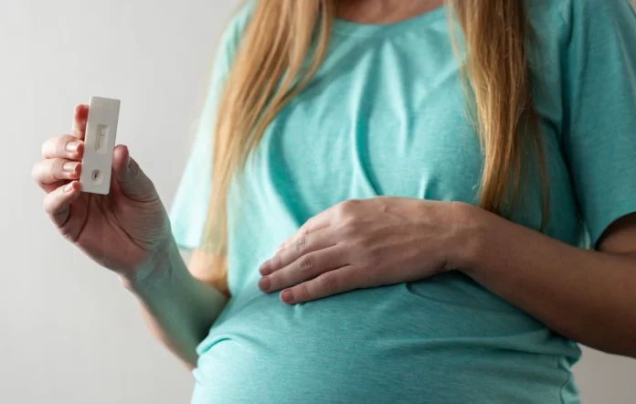 grávida segurando um teste rápido de HIV. OMS declara eliminação da transmissão vertical do HIV no Brasil