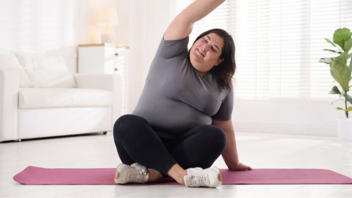 Mulher fazendo yoga no tratamento da obesidade