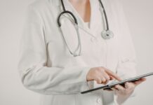 Tratamento da Malária em 2026: novos esquemas, tafenoquina e testagem de G6PD Médico revisando algoritmo de tratamento da malária com recomendações atualizadas sobre tafenoquina e testagem de G6PD.
