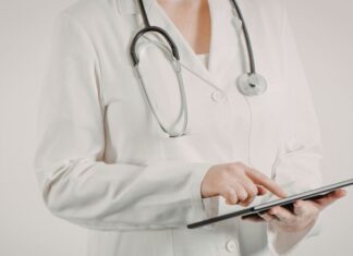 Tratamento da Malária em 2026: novos esquemas, tafenoquina e testagem de G6PD Médico revisando algoritmo de tratamento da malária com recomendações atualizadas sobre tafenoquina e testagem de G6PD.