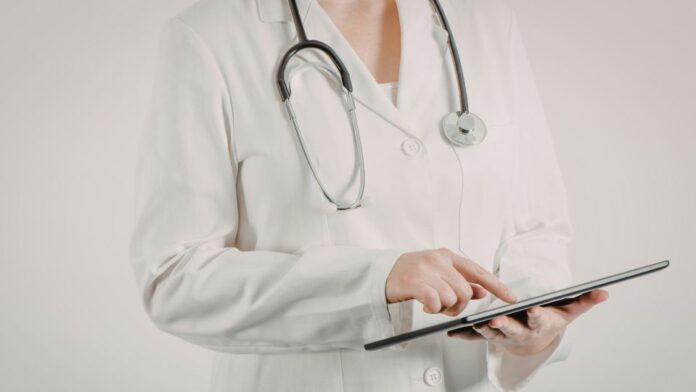medico no tablet Médico revisando algoritmo de tratamento da malária com recomendações atualizadas sobre tafenoquina e testagem de G6PD.