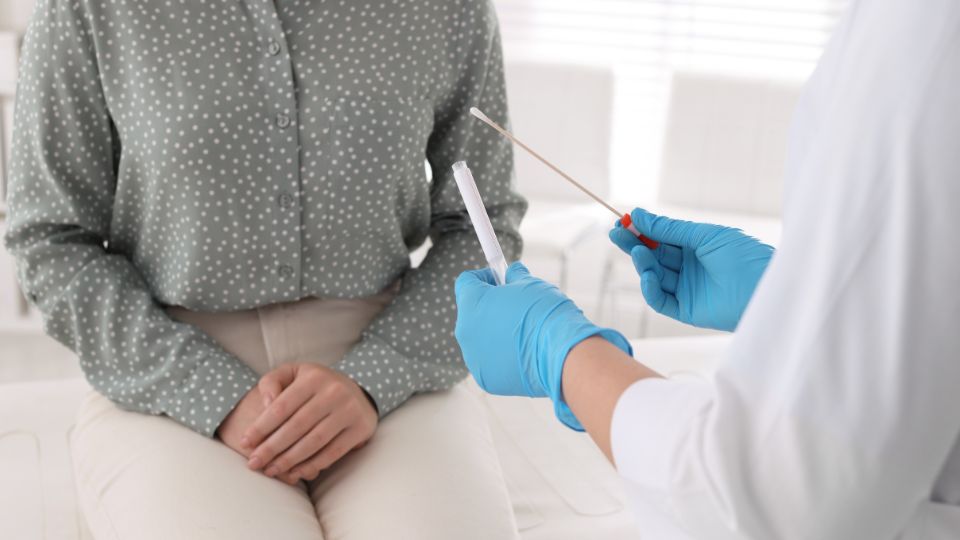 paciente em consulta ginecológica sendo orientada para coleta de amostra de lesões cervicais e vacinação contra hpv