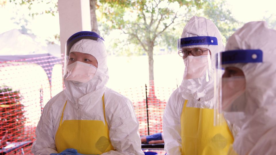 Profissionais de saúde utilizando equipamentos de proteção individual durante resposta a surto de Ebola