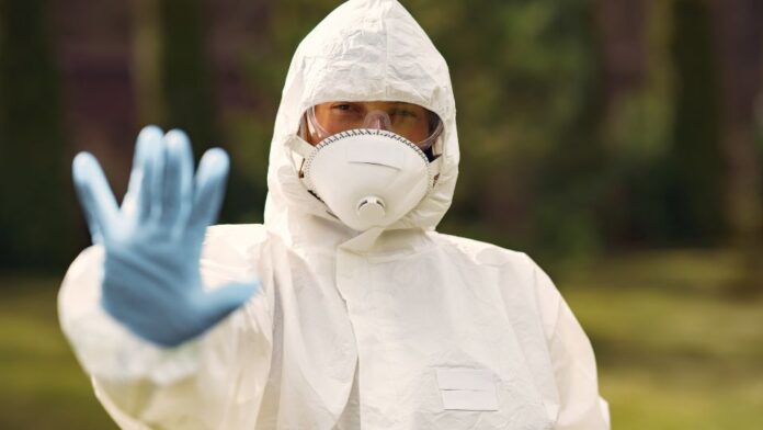 profissional de saúde usando EPI surto epidemiológico Profissionais de saúde utilizando equipamentos de proteção individual durante resposta a surto de Ebola.