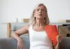 Anvisa aprova fezolinetanto (Veoza): o que muda no tratamento não hormonal da menopausa? mulher se abanando com leque por conta dos sintomas vasomotores da menopausa, que podem ser amenizados com fezolinetanto aprovado pela Anvisa