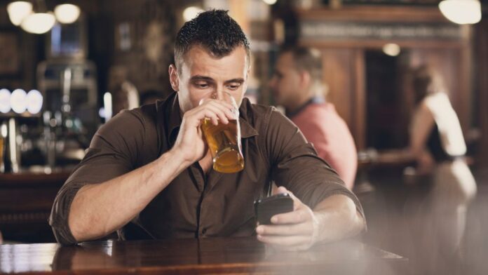 homem bebendo cerveja no celular homem tomando cerveja acessando o modera brasil pelo celular, ferramenta digital integrada ao Meu SUS Digital