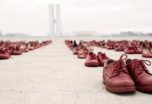Feminicídio na CID-11: proposta brasileira busca qualificar dados de mortalidade vários sapatos vermelhos alinhados, representando a invisibilidade da violência de gênero e a importância da identificação do feminicídio na CID-11 para a saúde